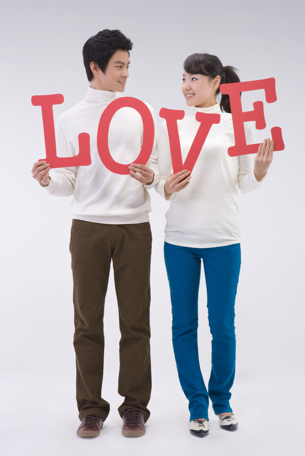 拿着LOVE英文字母的开心情侣图片
