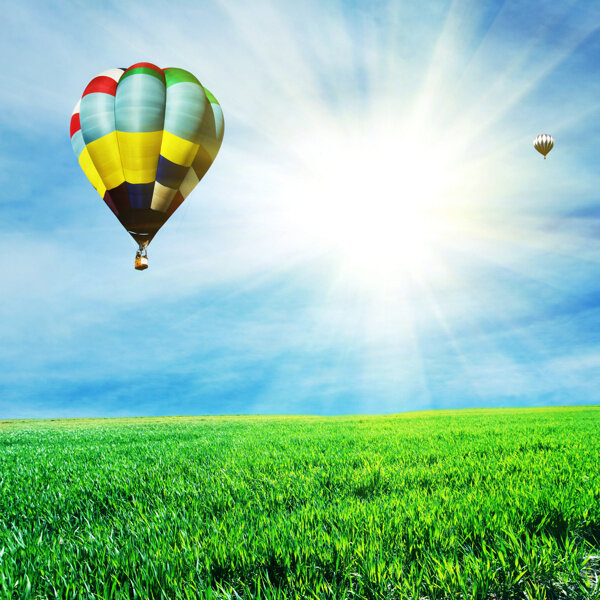 阳光下草地上的热气球图片