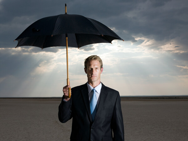打着伞表情严肃的外国商务男人图片
