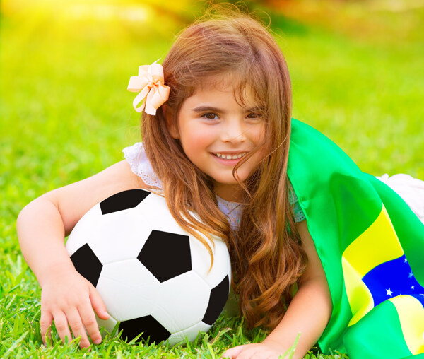 草地上抱足球的女孩图片