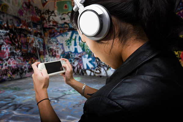玩PSP游戏听音乐的时尚青年图片