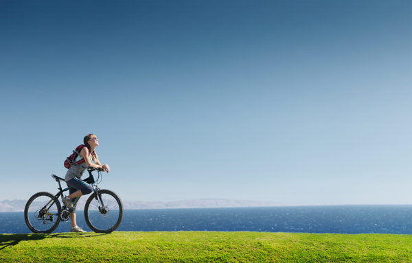 草地上骑自车的女人图片