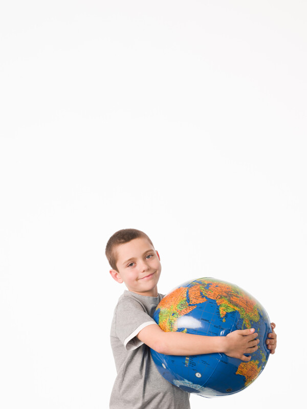 抱着地球仪的小男孩高清素材图片