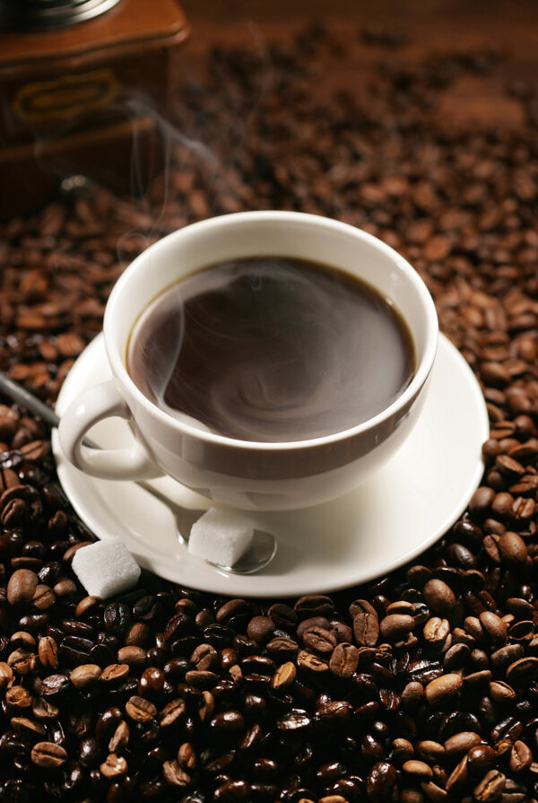 咖啡豆上一杯冒热气咖啡图片