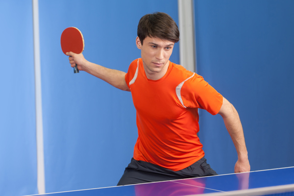挥乒乓球拍的男运动员图片