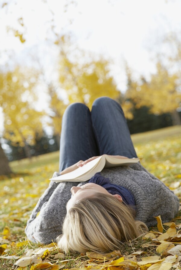 拿书本躺在草地上的美女图片