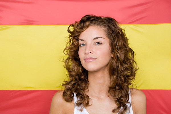 西班牙国旗背景前的卷发美女图片