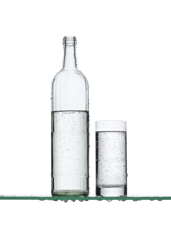 玻璃板上的一瓶水和一杯水图片