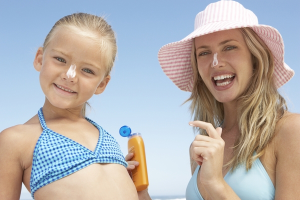 沙滩上擦防晒乳的母女图片