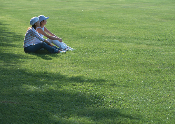 坐在草地上的两个美女图片