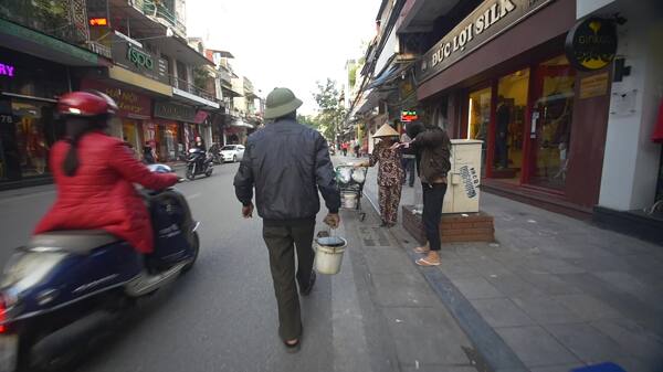 在越南街上用水桶走路的男人