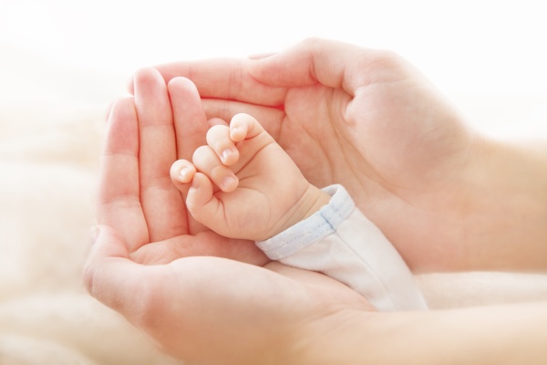 成年人的双手捧着的婴儿小手图片