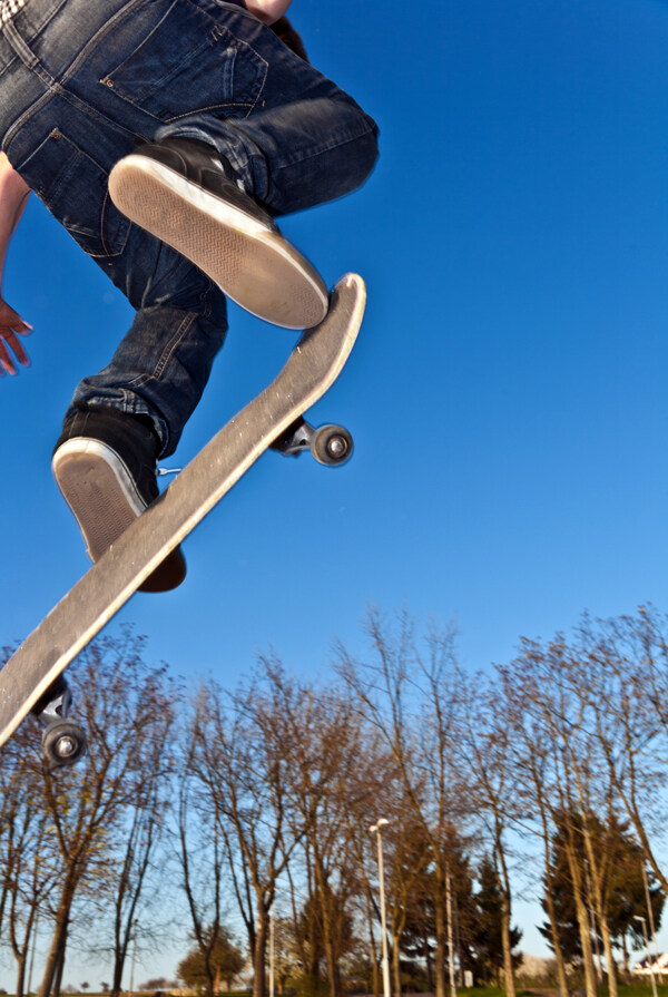 跳跃起来的滑板男孩图片
