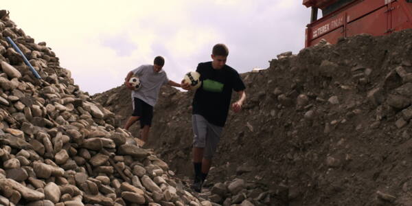 携带足球的采石场股票视频两个男孩